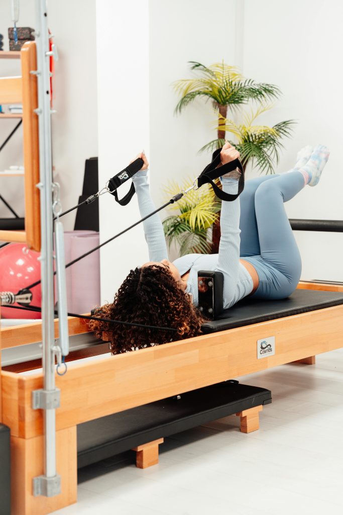Brunette woman practicing Pilates on a reformer inside a gym in Yalova, Türkiye.